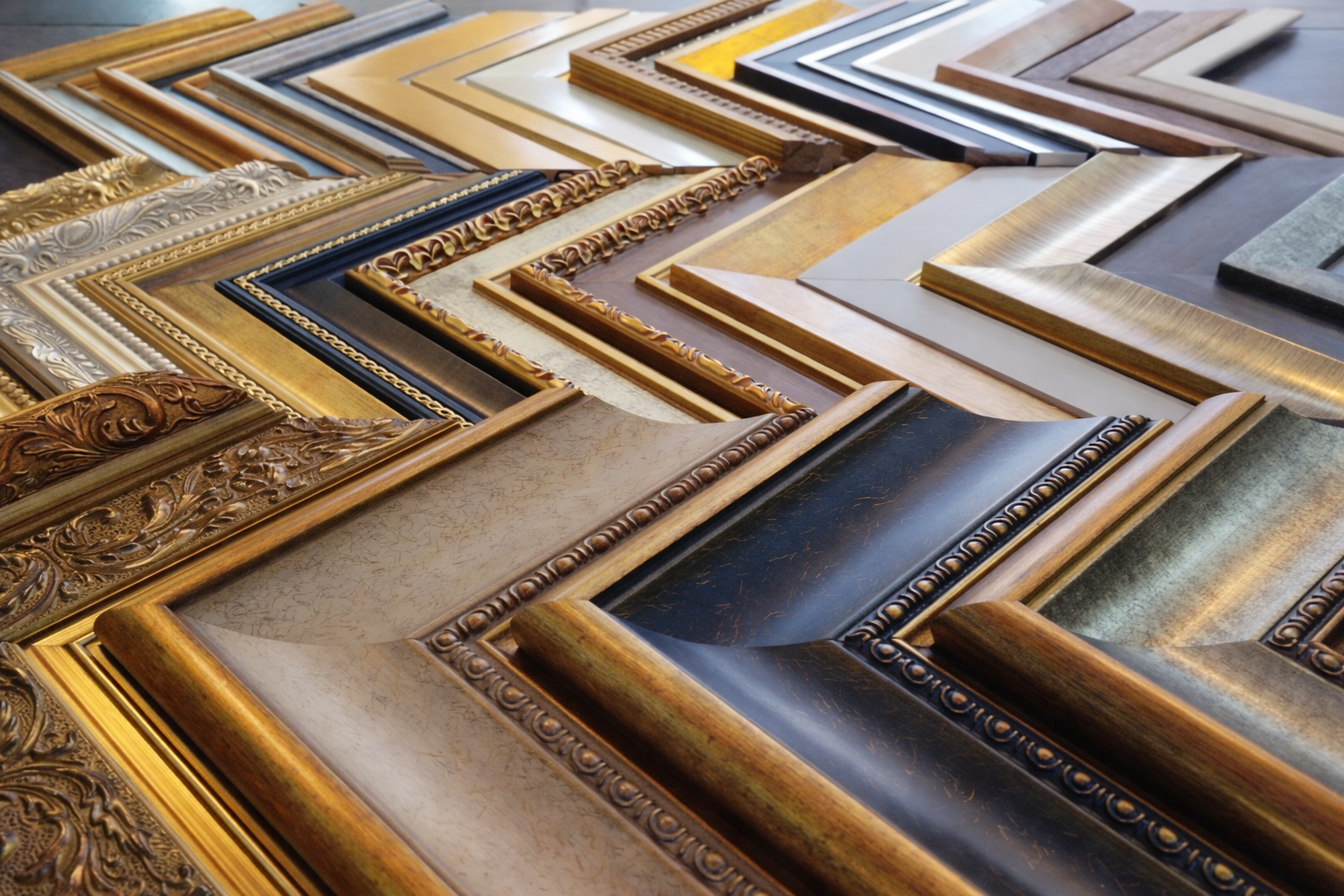 Interior of a high-end framing workshop with antique tools and stacks of high-quality wood mouldings